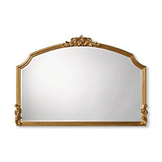 an ornate gold framed mirror on a white wall