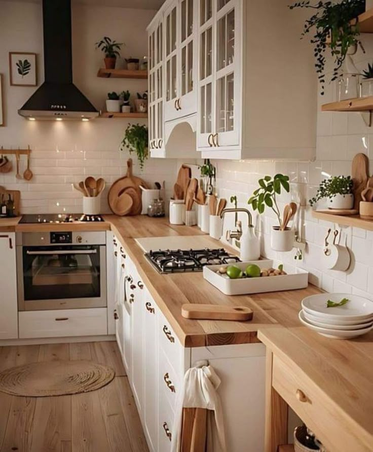 a kitchen filled with lots of wooden counter top next to white cabinets and counters topped with pots and pans