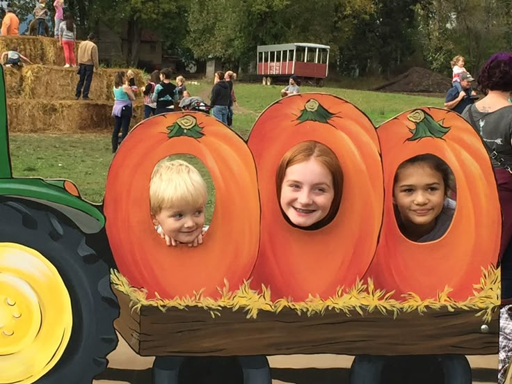 two children are sitting in a pumpkin shaped vehicle