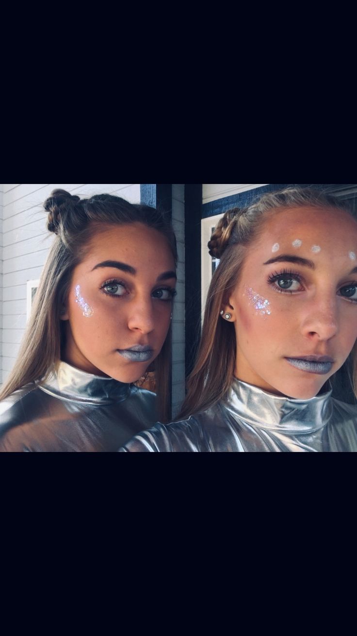 two women with makeup on their faces and one is looking at the camera while wearing silver