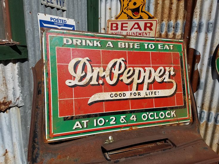 an old metal sign on the side of a building that says dr pepper at 10 - 2 & 4 oclock