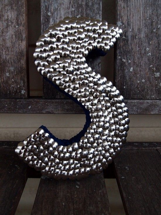 a metal letter that has been made to look like it is covered in silver balls