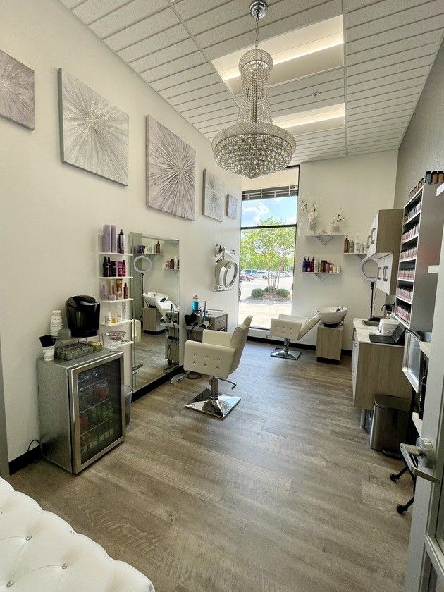 the inside of a hair salon with chairs, mirrors and other items on the wall