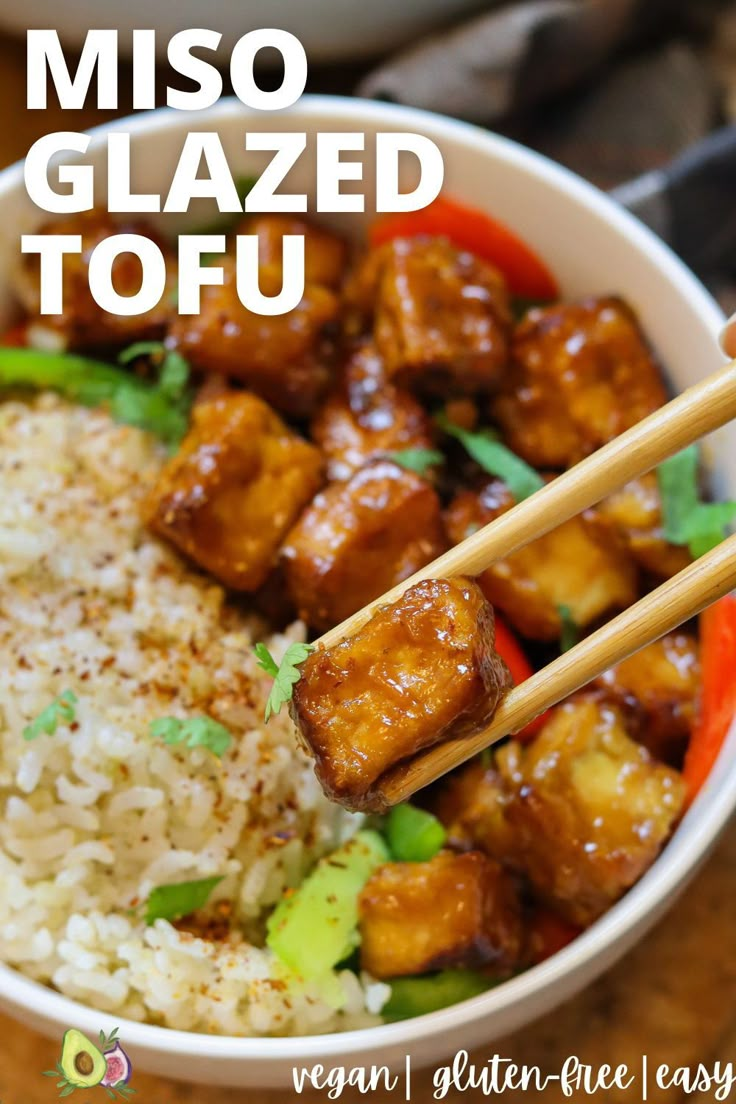 a bowl filled with rice, meat and veggies next to chopsticks