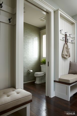 an open door leading to a bathroom with white walls and wood flooring on the side