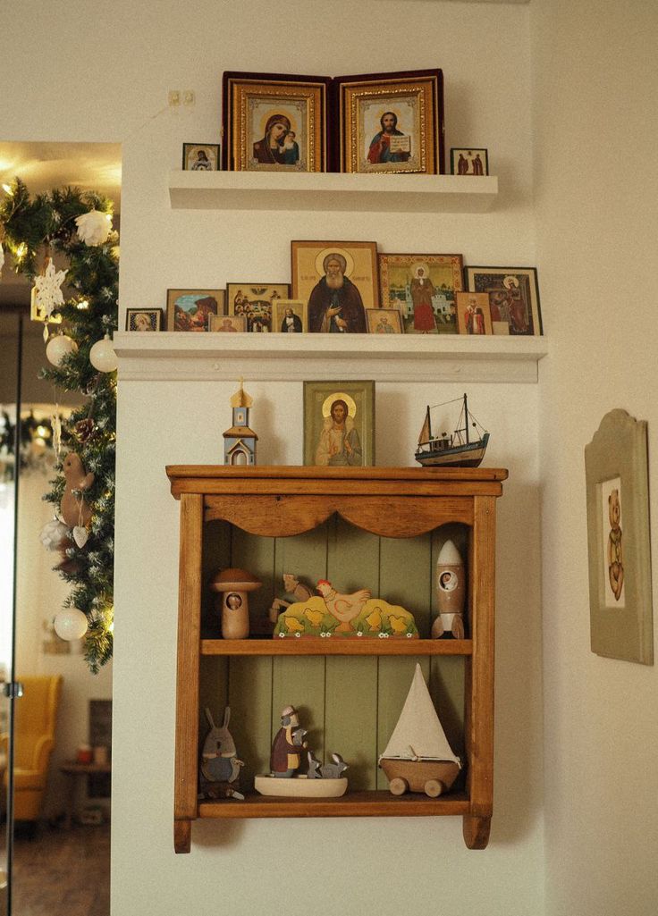 a shelf with pictures and figurines on it in the corner of a room