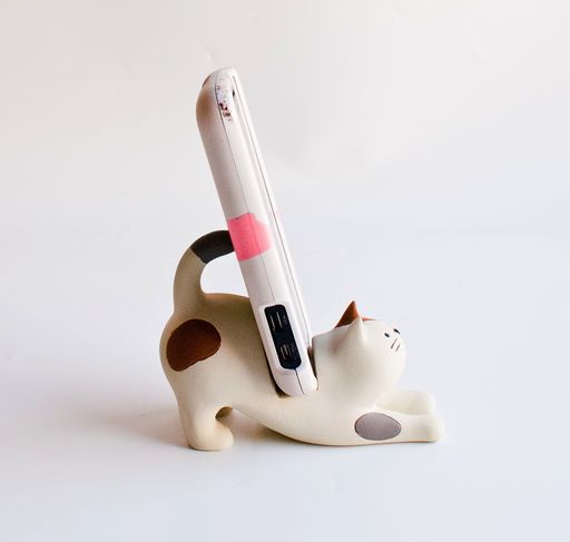 a cat figurine with a pen sticking out of it's back