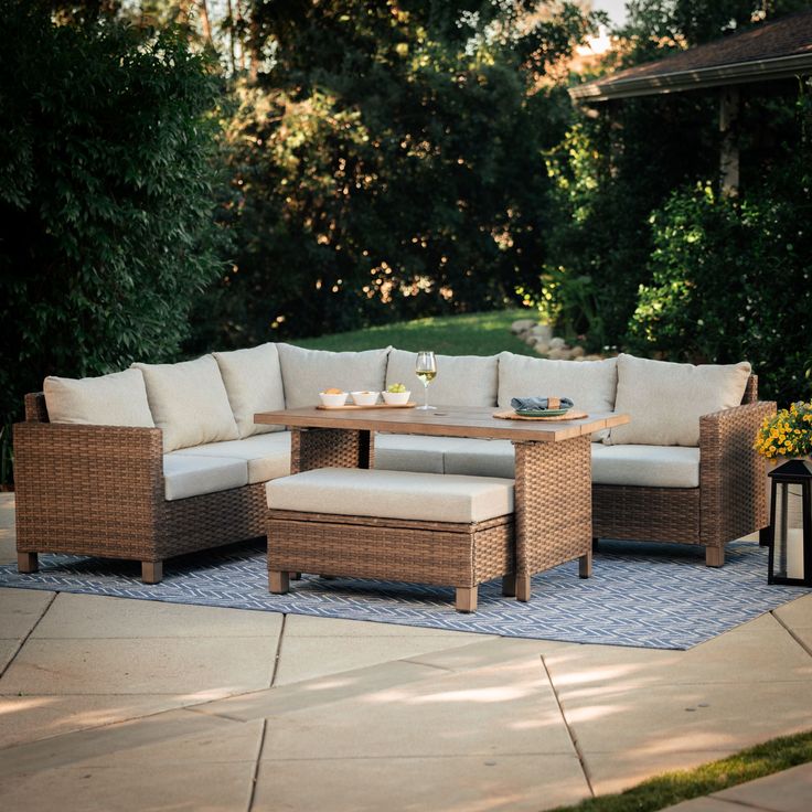 an outdoor patio with wicker furniture and blue rug