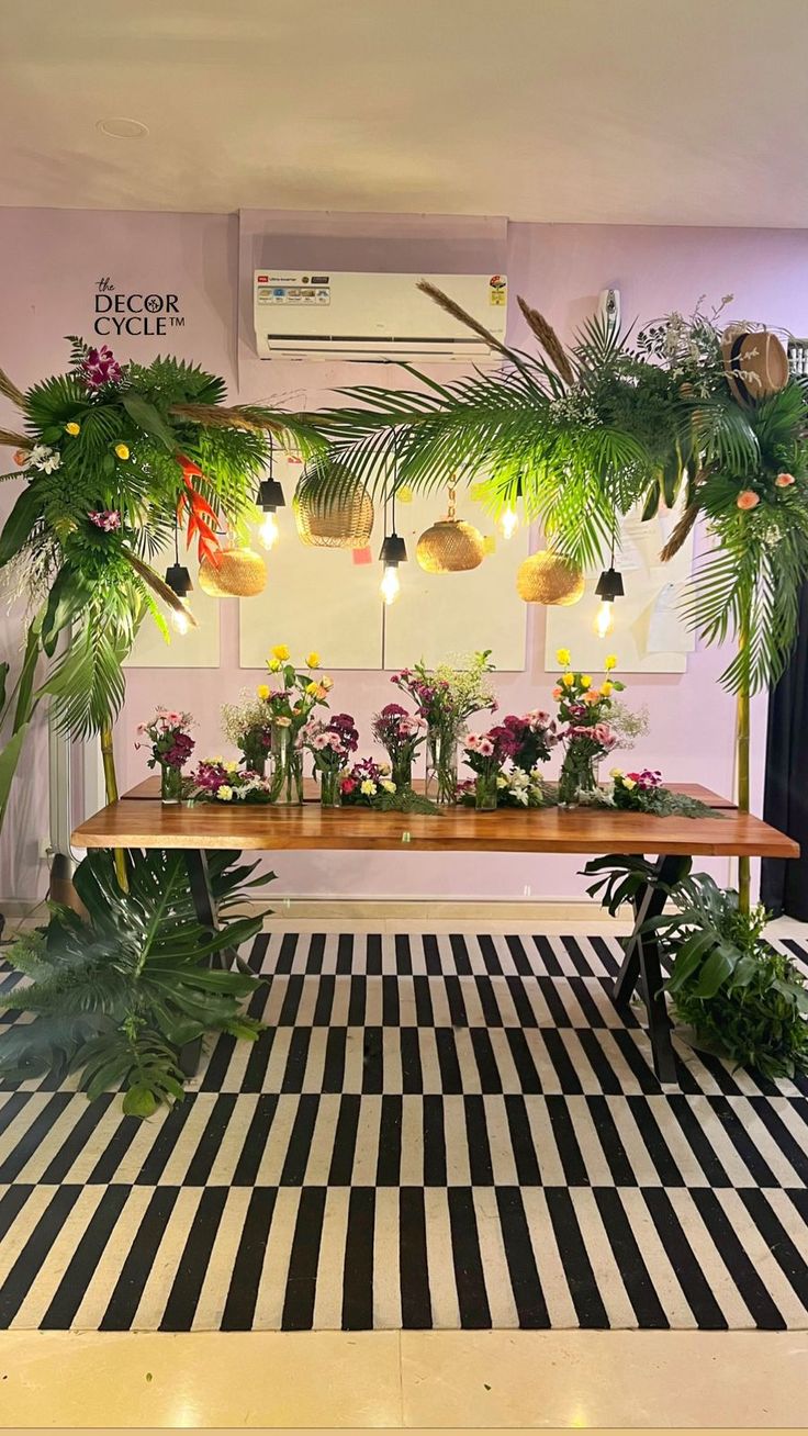 a table with plants and lights on it in a room filled with black and white checkered flooring