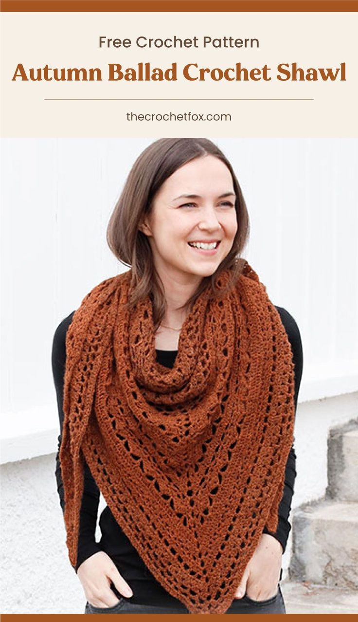 a woman wearing a brown shawl standing in front of a white building smiling at the camera