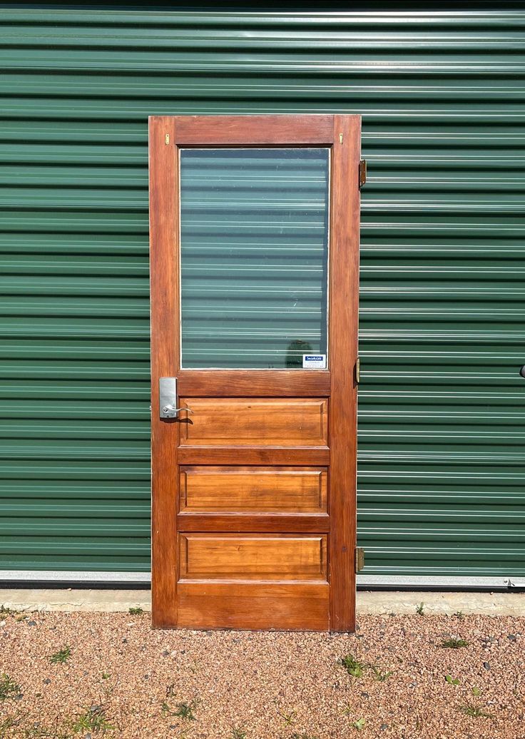 a wooden door sitting in front of a green wall