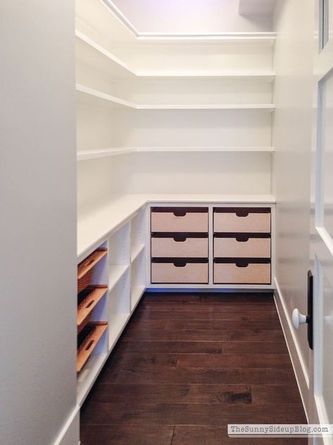 an empty walk in closet with drawers and shelves