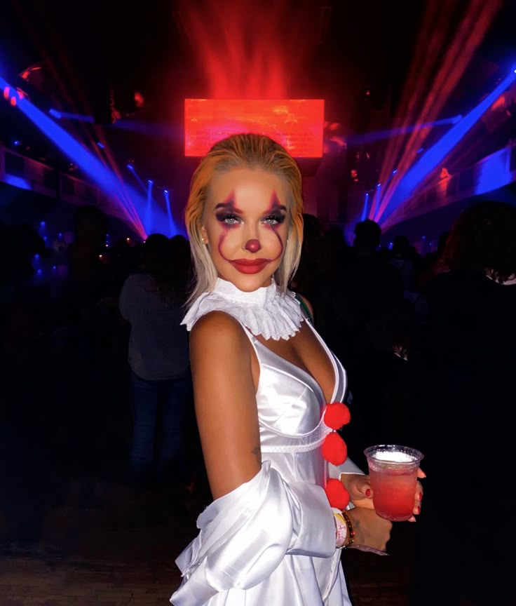 a woman dressed up as a clown holding a drink