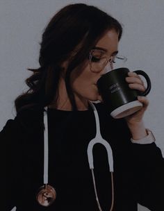 a woman wearing glasses and holding a coffee cup