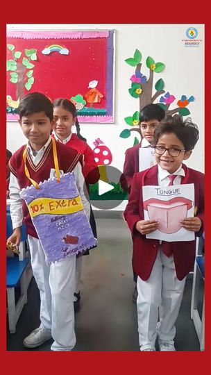 some kids are holding up signs in front of their school desks and smiling at the camera