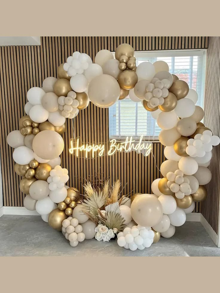 a happy birthday balloon arch with balloons and pineapples on the front, surrounded by white and gold balloons