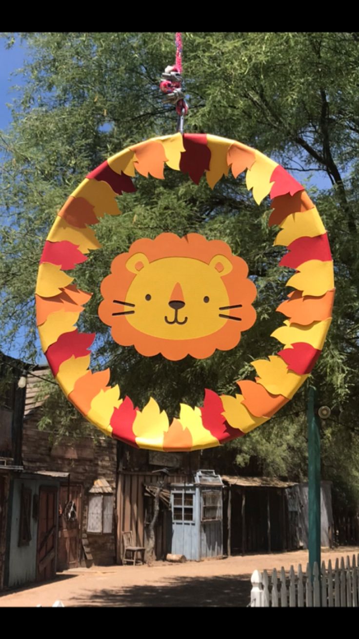 a paper plate with a lion face hanging from it's center pole in front of a house