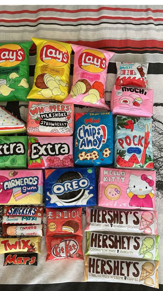 a pile of candy sitting on top of a bed next to each other in front of a blanket