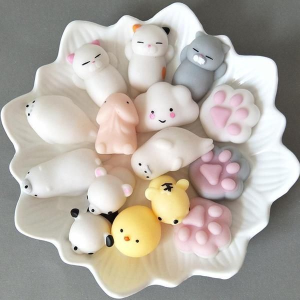 a white bowl filled with lots of small plastic animals on top of a table next to each other