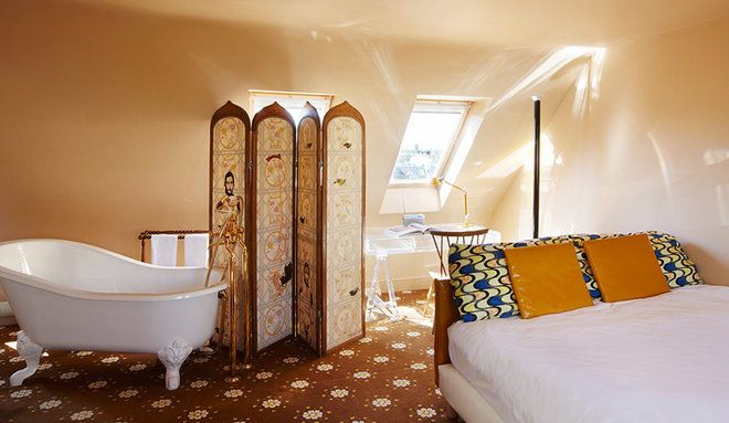 a bathroom with a bathtub, sink and bed in it