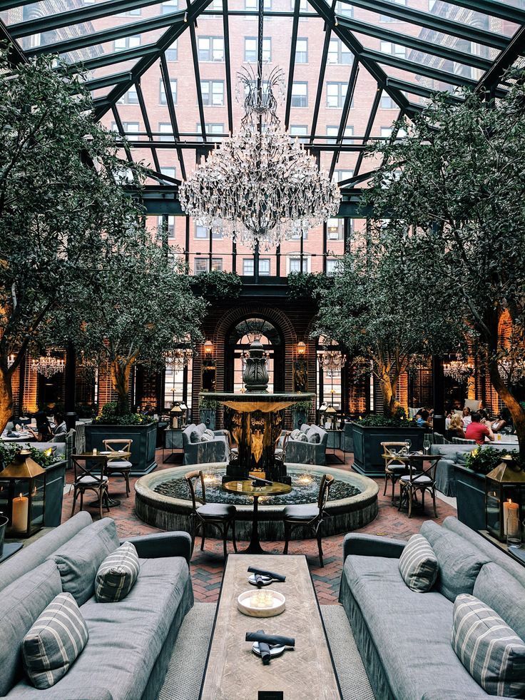 a large room with couches, tables and chandelier hanging from the ceiling