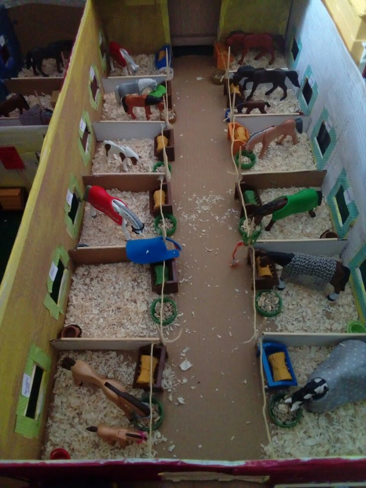 several toy animals in wooden crates filled with sand