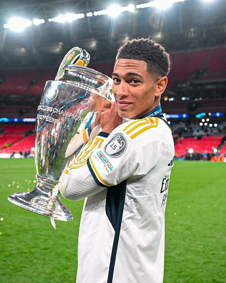 the soccer player is posing with his trophy