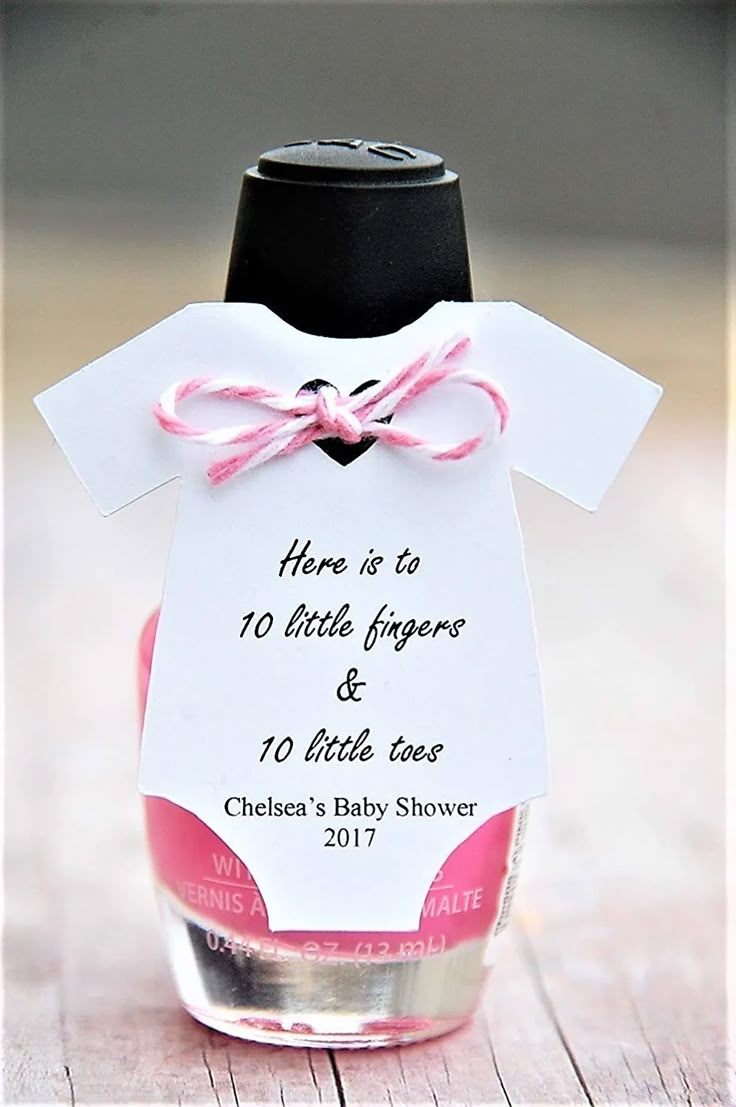 a baby shower bottle with a tag attached to it that says, here is to 10 little fingers and 10 little toes