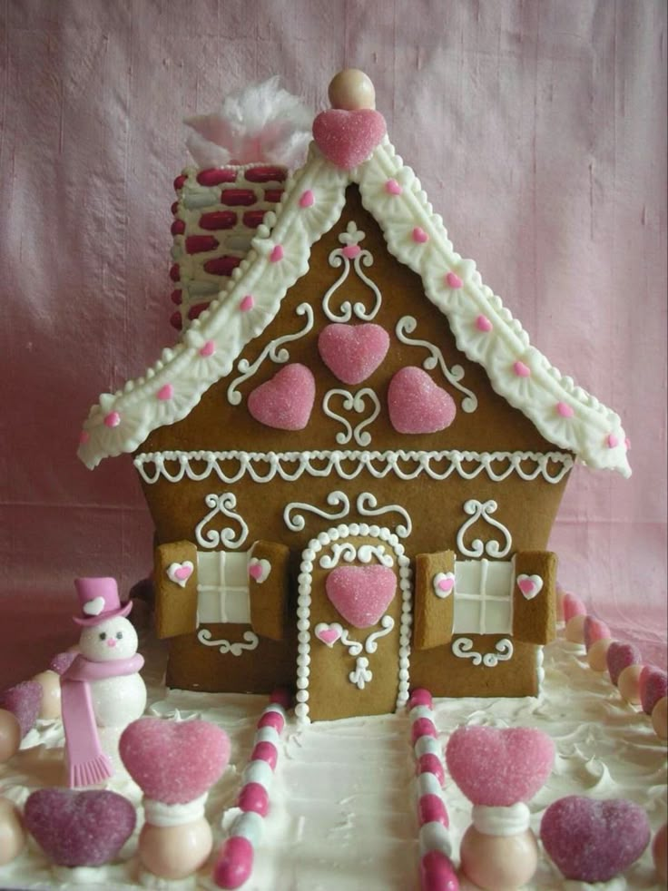 a gingerbread house decorated with pink and white icing