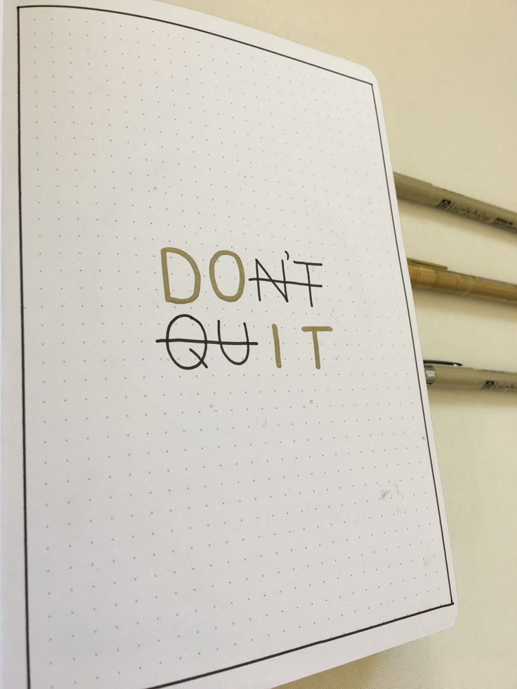 an open notebook with the words don't quit on it