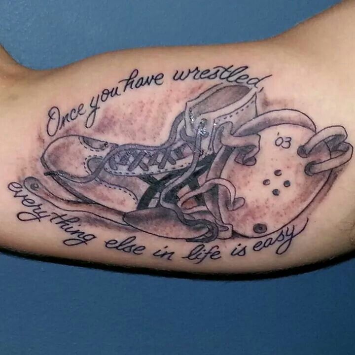 a tattoo on the arm of a man with an image of a shoe and words