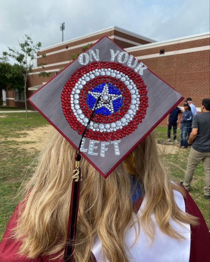 a woman wearing a graduation cap with the captain's shield painted on it,