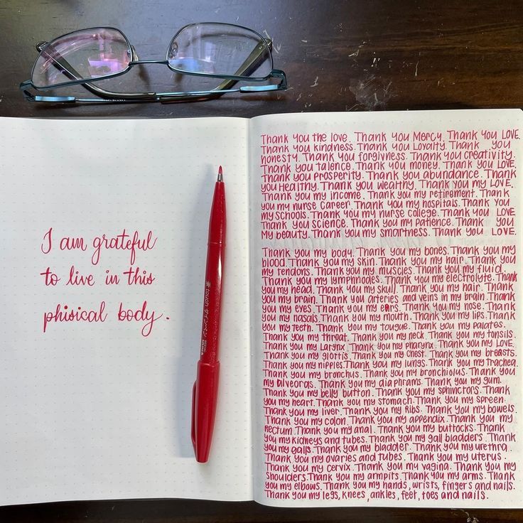 an open book with writing on it next to a pair of glasses and a pen