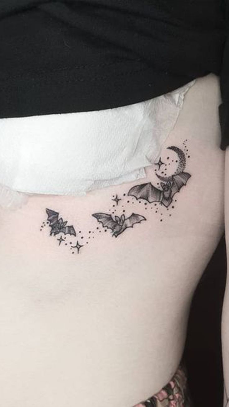 a woman's lower back with bats and stars on her side ribcage