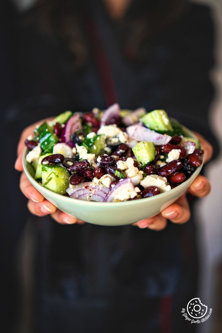 a person holding a bowl filled with vegetables