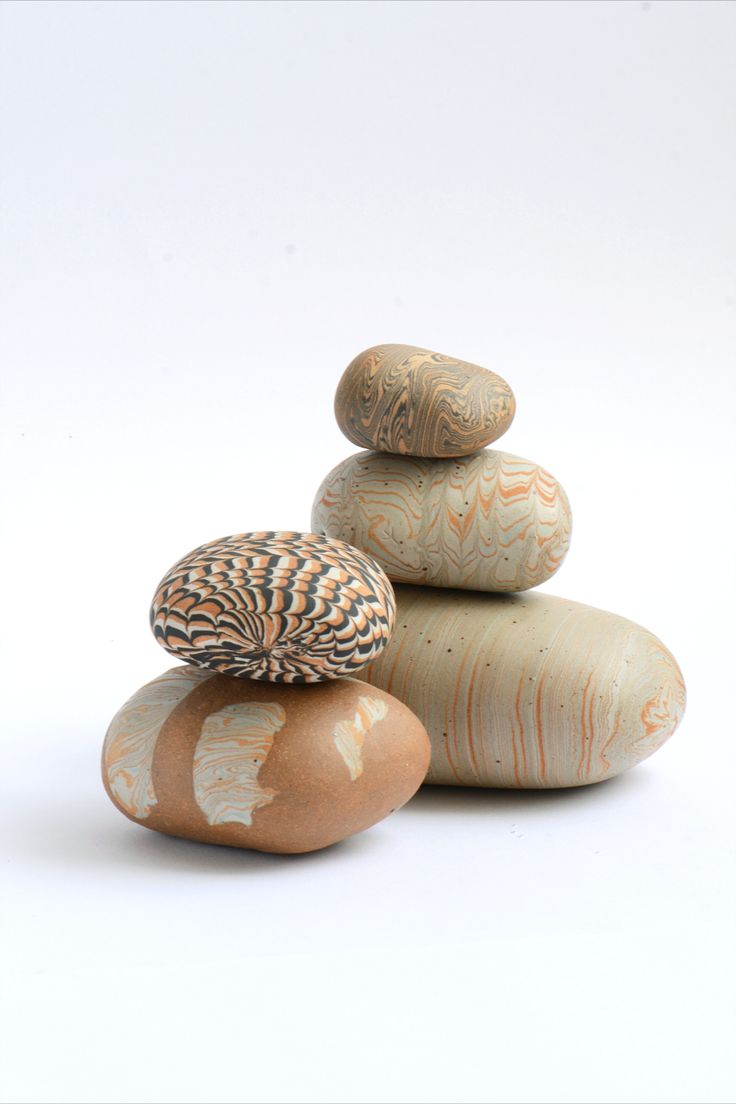 three rocks stacked on top of each other in different shapes and sizes, one with an orange shell