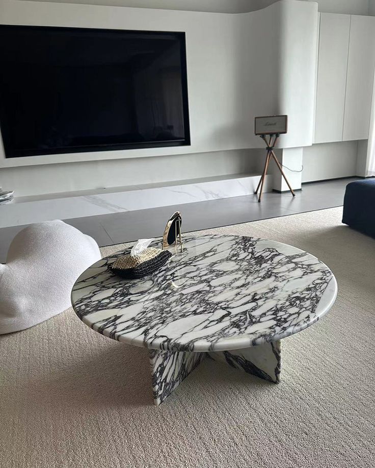 a marble coffee table in front of a flat screen tv