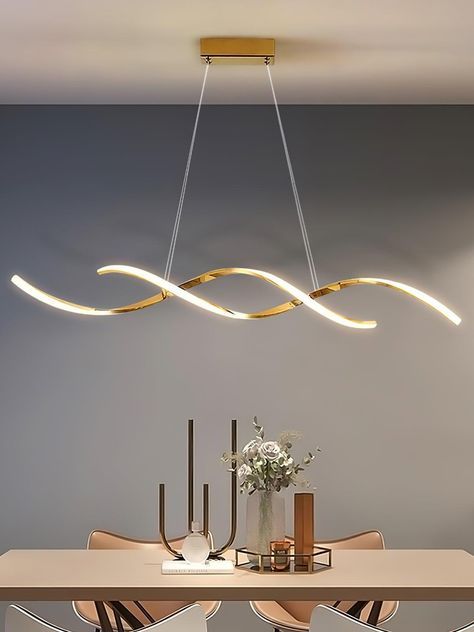 a modern chandelier hangs over a dining room table with chairs and vases