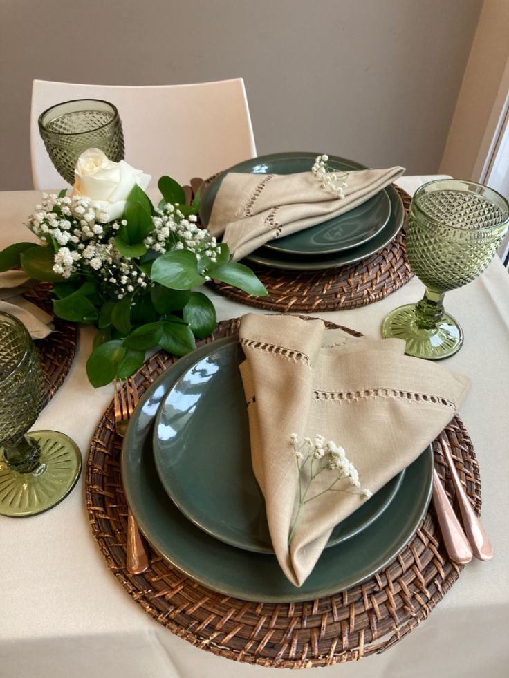 a table set with plates, napkins and flowers