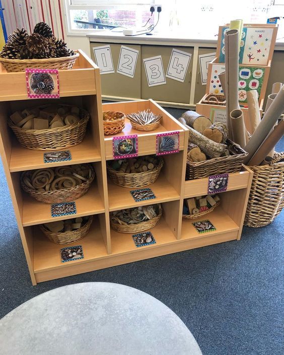 several baskets are stacked on top of each other in front of a table with books