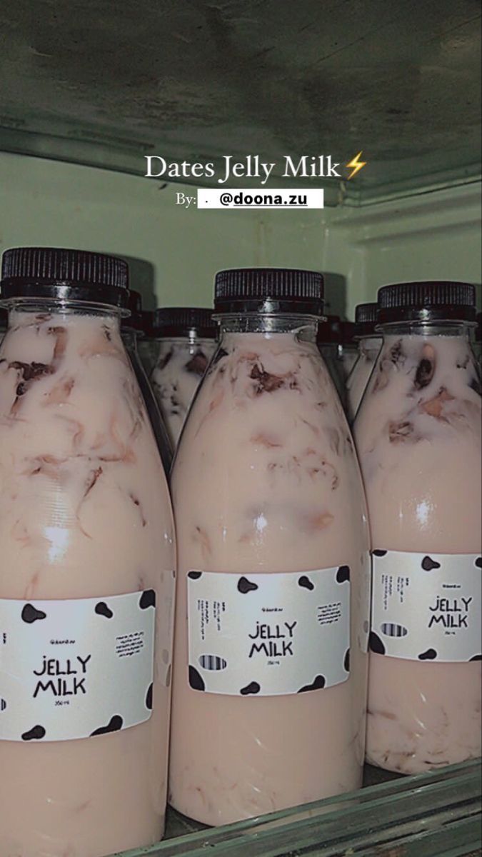 four jars of jelly milk sitting on top of a shelf