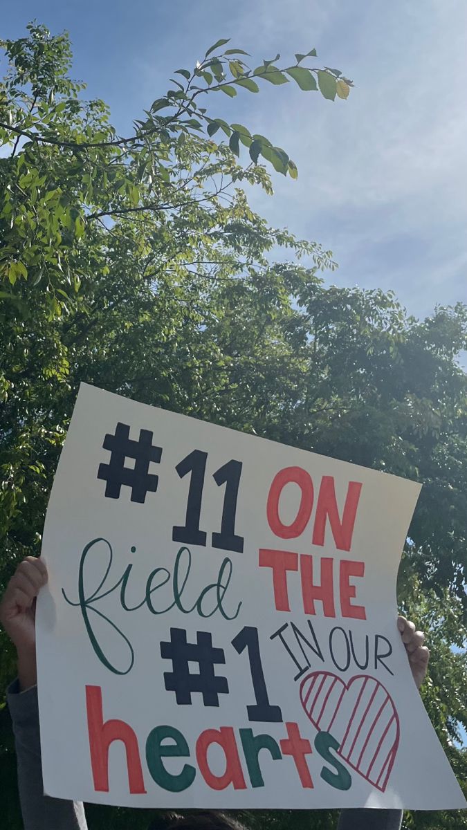 a person holding up a sign that says 11 on the field your heart's