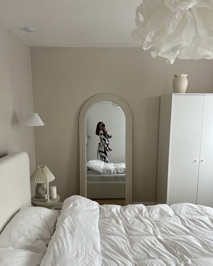 a bedroom with a white bed, dresser and mirror in it's center area