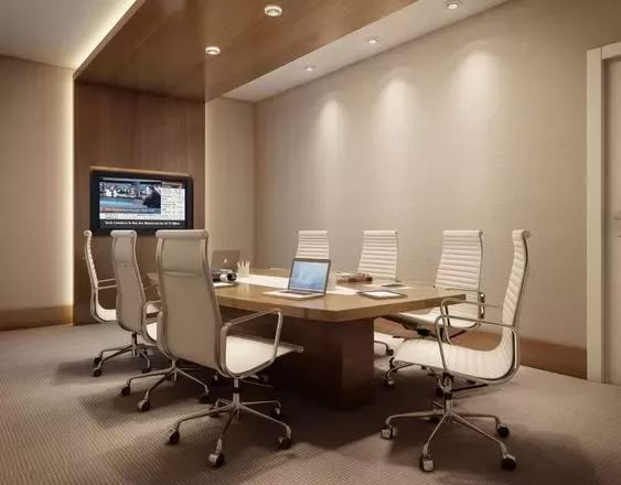 a conference room with chairs and a television in the corner, along with a large wooden table