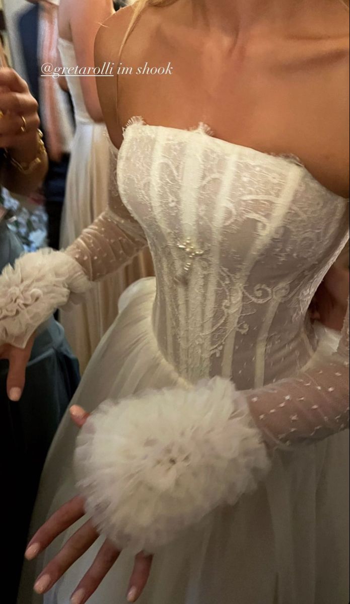 a woman in a white wedding dress and gloves