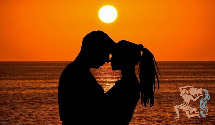 the silhouette of a man and woman kissing in front of an orange sky at sunset