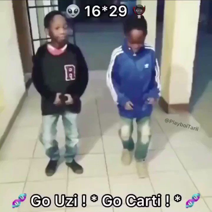 two young boys standing next to each other on tiled floored area with white walls