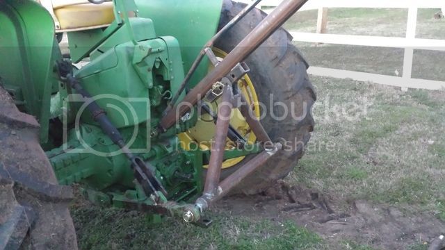 an old green tractor parked in the grass