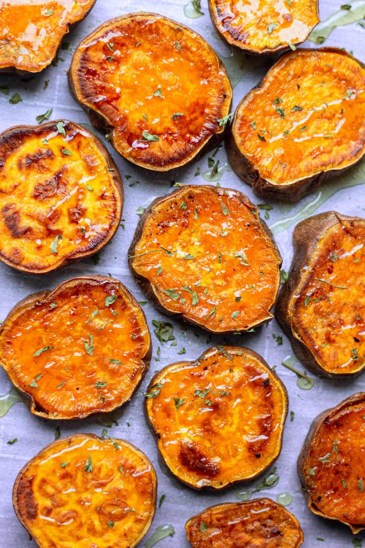 baked sweet potatoes with cheese and herbs on a baking sheet