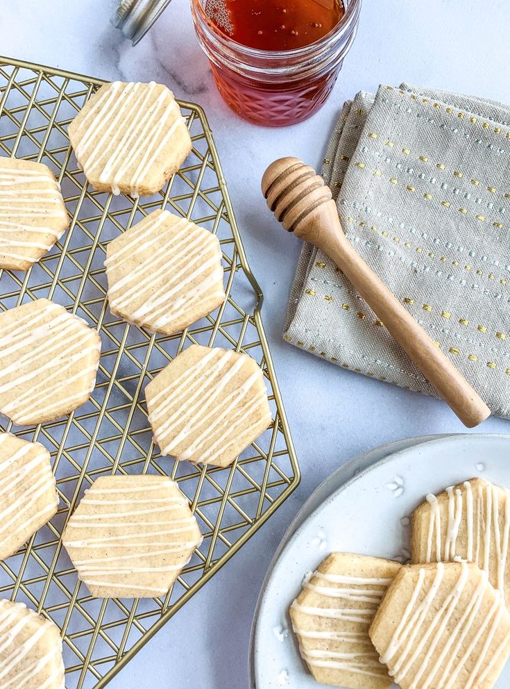 honey sugar cookies on a cooling rack next to a jar of honey